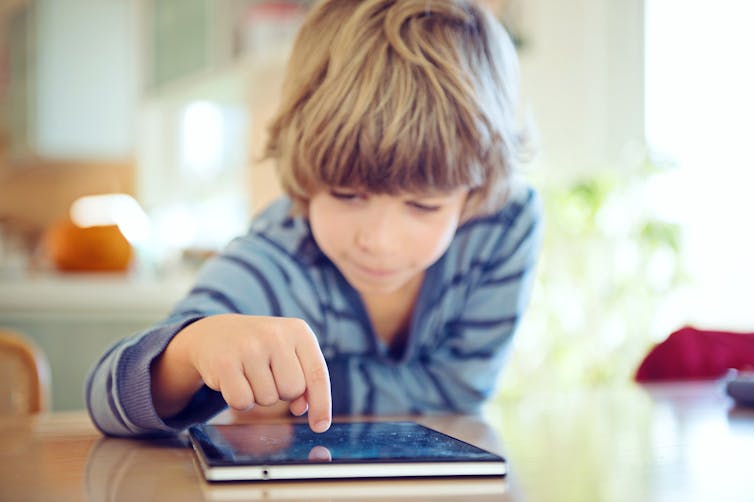 young boy using touch screen tablet