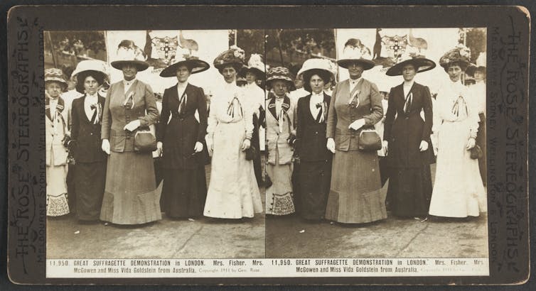 Five women, whole-length, full face, wearing full length gowns, jackets, wide brimmed decorated hats, standing in a row. Text reads: Mrs. Fisher, Mrs. McGowen and Miss Vida Goldstein from Australia.
