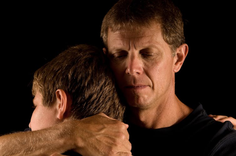 Father and son hugging.