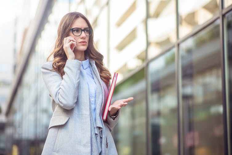 Woman walking, looking concerned on phone.