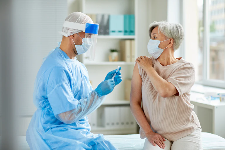 A health-care worker administers a vaccine to a woman.