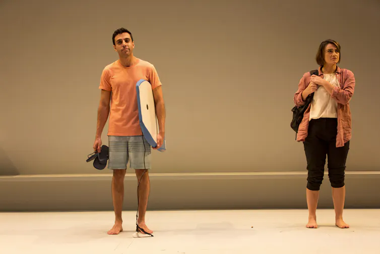 A Middle Eastern man with a bogie board. A white woman with a backpack.