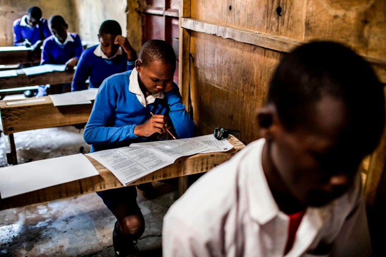 A row of uniformed students take the national primary school exam.