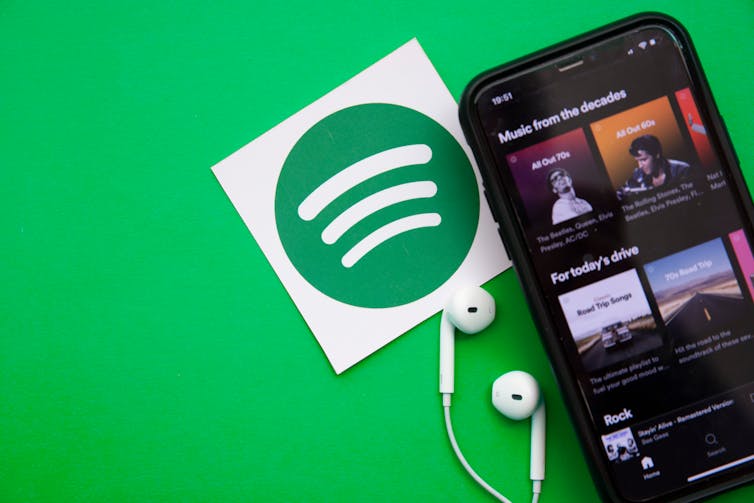 A phone showing Spotify playlists against a green blackground