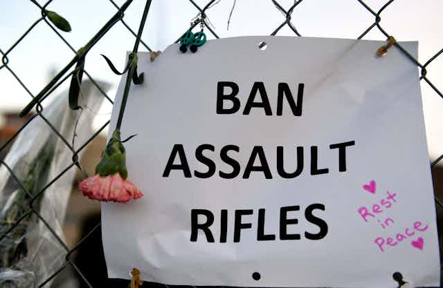 A sign on a fence in Boulder that says "Ban assault rifles"