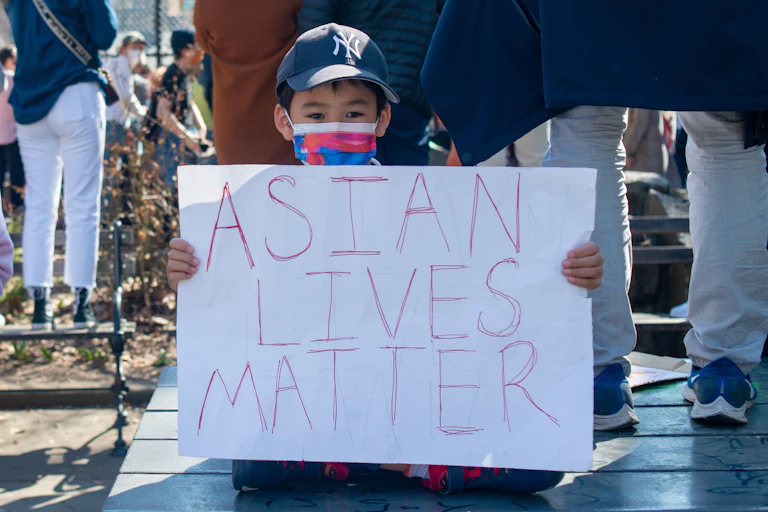 As child holds a 'Asian lives matter' sign