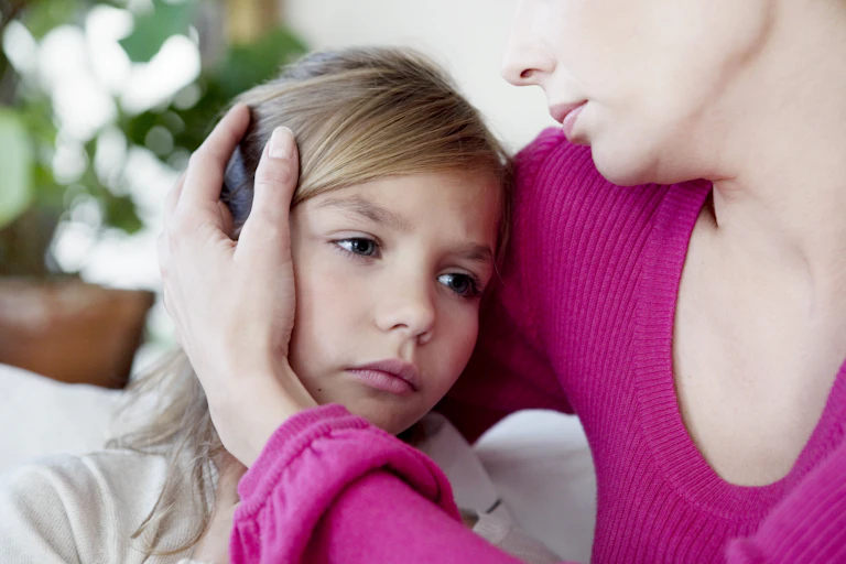 A tired child being comforted by a parent