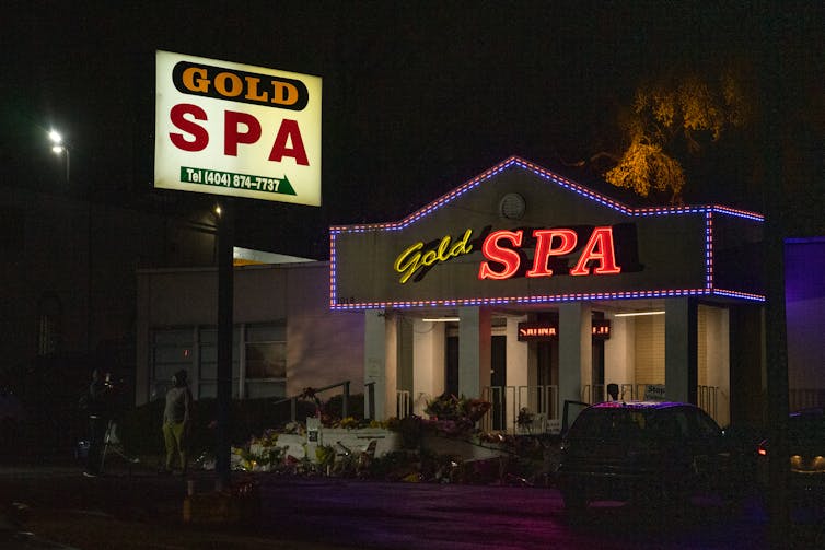 Exterior of the spa at dark with flowers all around it