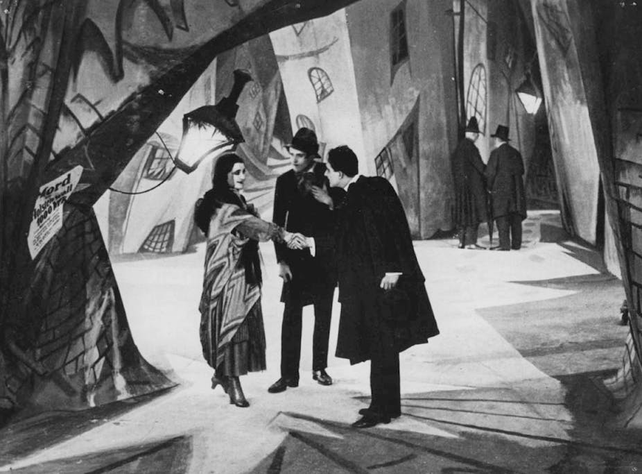 Black and white still of three people talking in film The Cabinet of Dr Calgari.