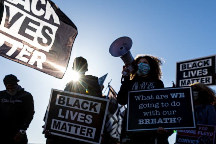 Protesters hold 'Black Lives Matter' signs.