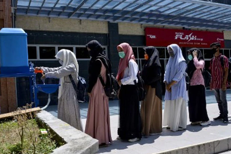 Students wash their hands amid concerns over the Covid-19 coronavirus before taking a college university exam in Banda Aceh.