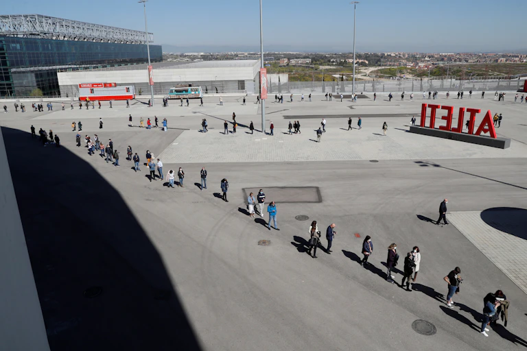 A line of people wait to get a vaccine in Madrid