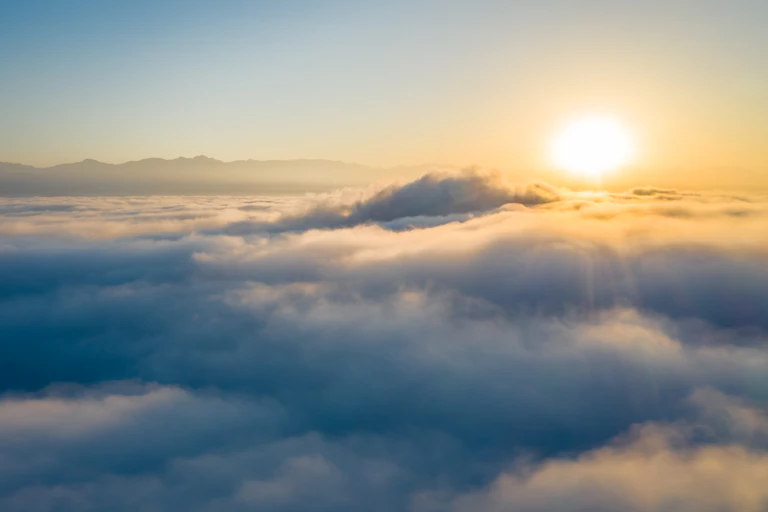 Sun shining on clouds above Earth