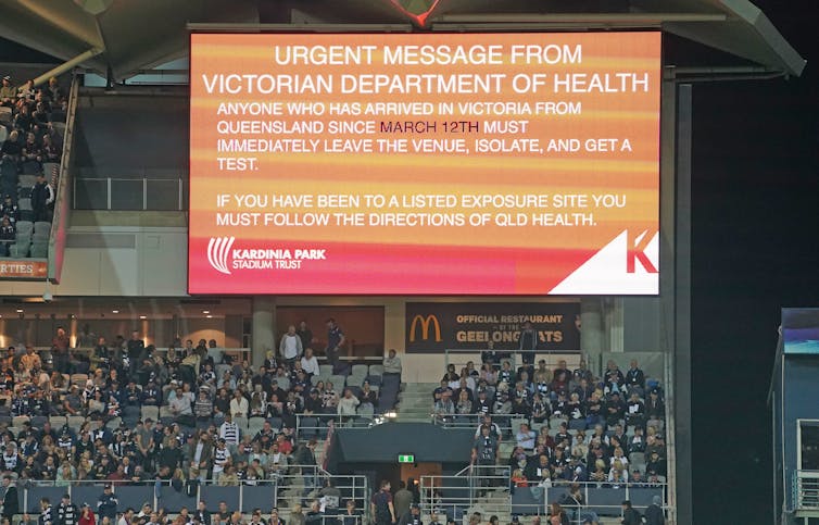 A sign at the football calling for people from Queensland currently in Victoria to get tested for COVID-19 and isolate