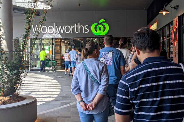 Shoppers queueing up at a Woolworths supermarket in Brisbane