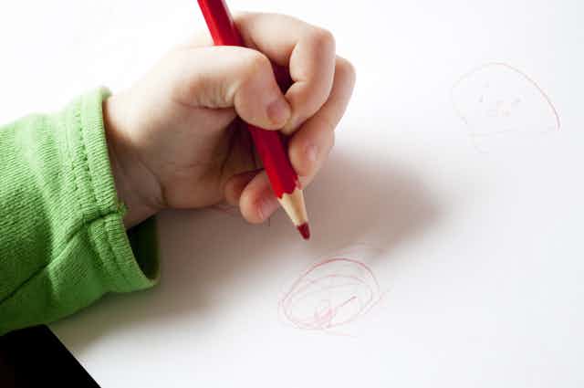 Child drawing with their left hand