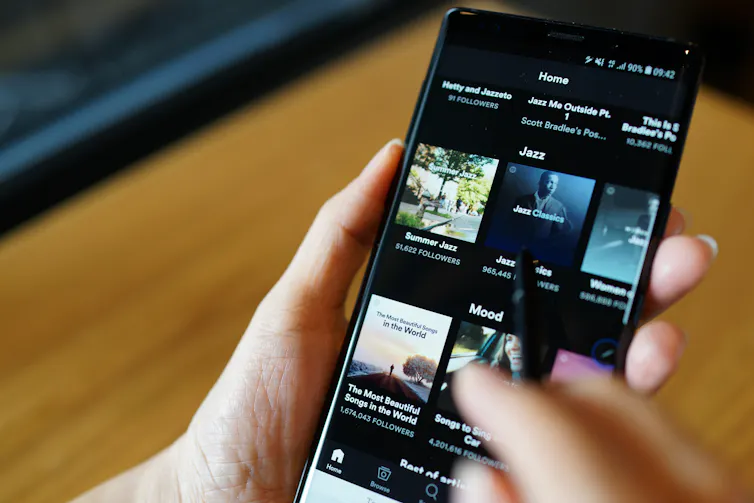 Close up of a phone with the Spotify application on the screen.