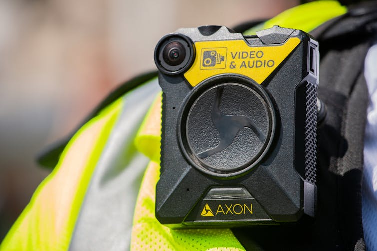 The shoulder of a police officer in the UK with a bodycam on it