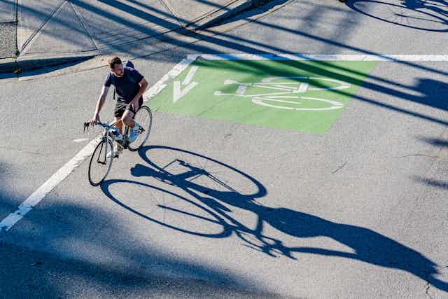 A cyclist crosses an urban intersection.