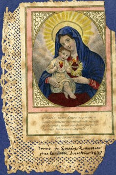 A holy card depicting the Virgin Mary holding infant Jesus with Sacred Heart