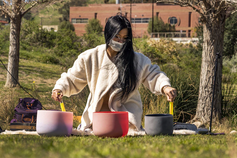 A woman performs with crystal bowls