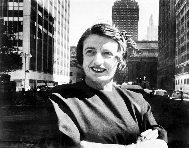 Ayn Rand sits with her arms folded outside Grande Central Terminal in New York City