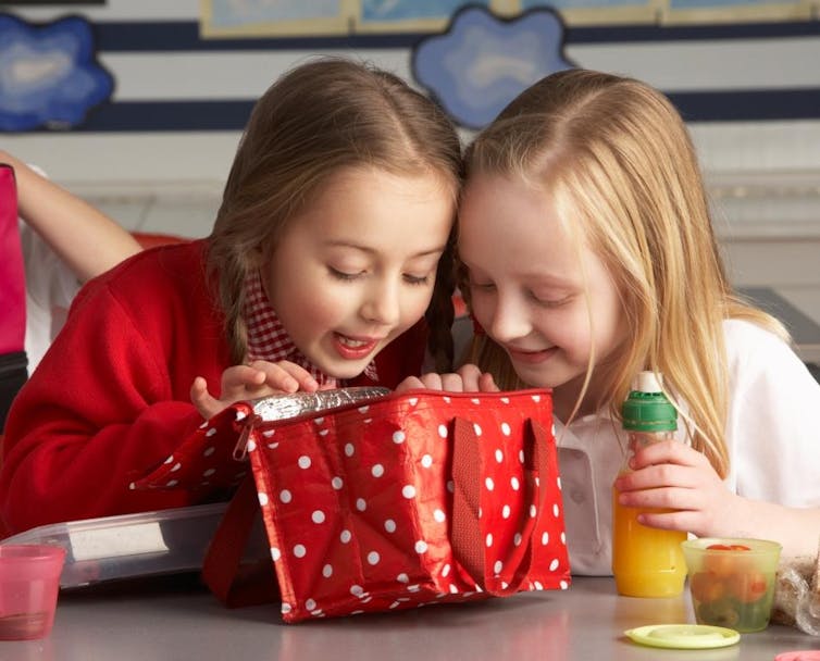 School children sharing packed lunch