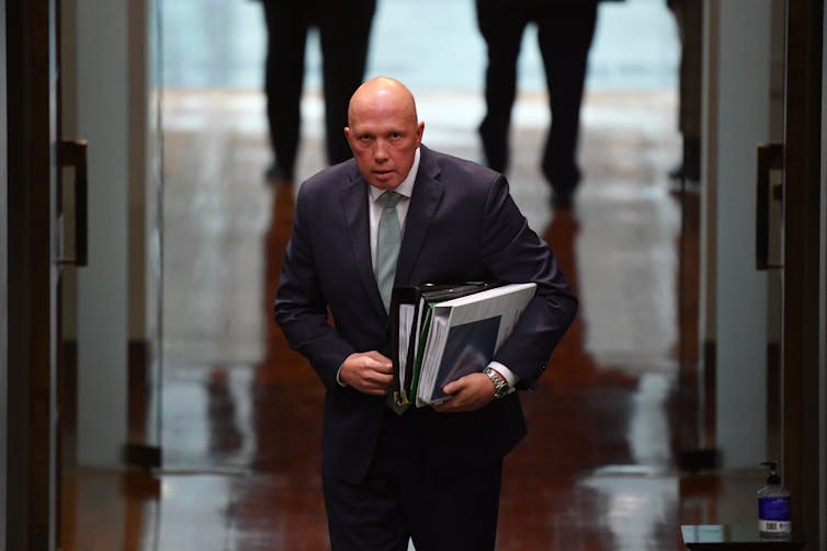 Peter Dutton walking and carrying files