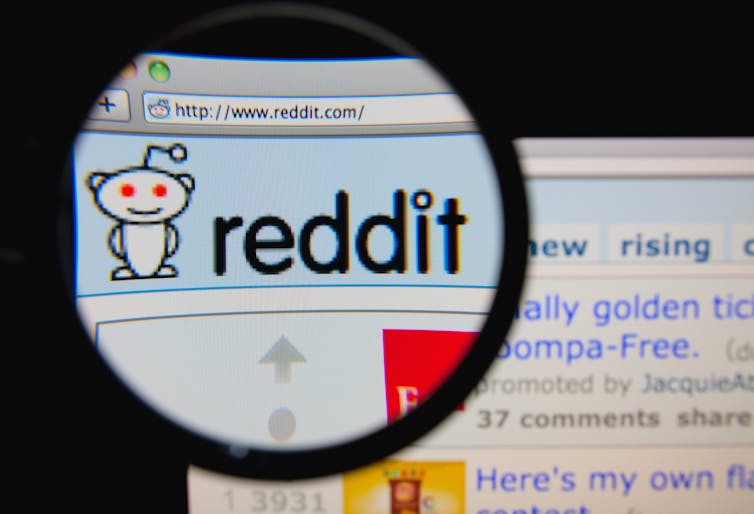 A magnifying glass over the Reddit logo on a web browser