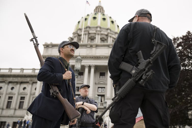 Two men with guns outside the Pennsylvania state capitol