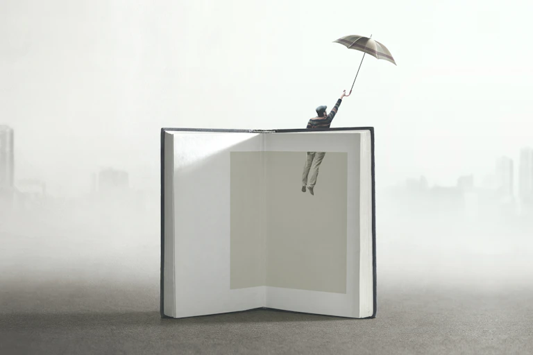 A figure of a man is drawn out of a book by an umbrella