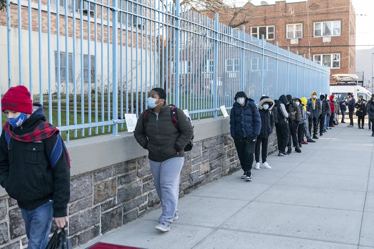 Grade school students line up to walk to school.