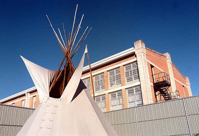 Tipi outside in front of a building.