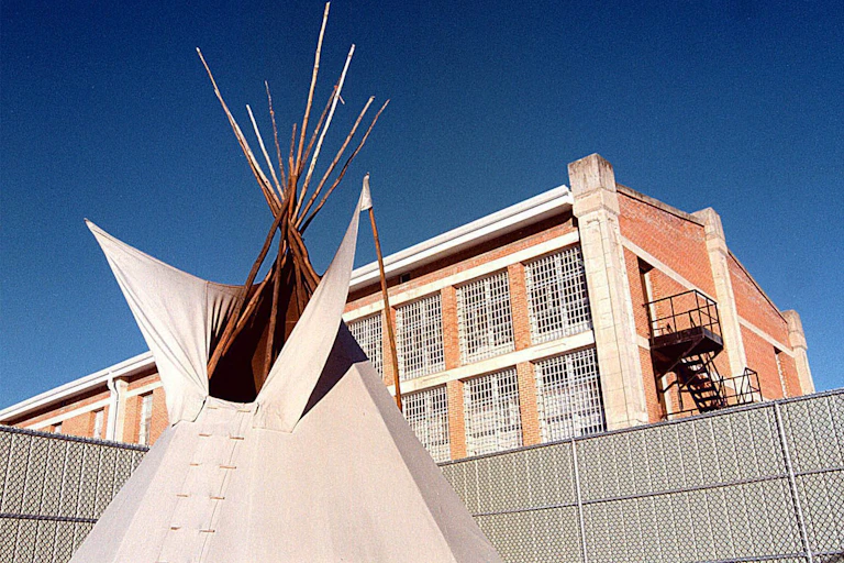 Tipi outside in front of a building.