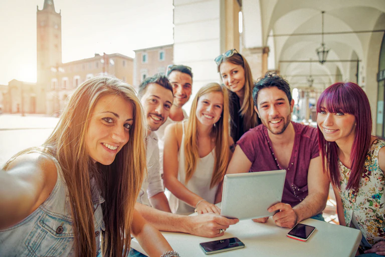 group of university students around a table uploading a group photo
