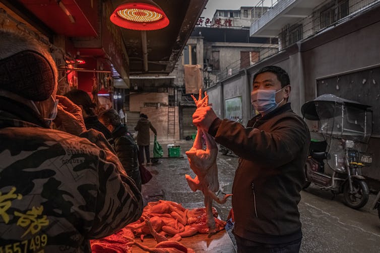 Homem usando máscara em um mercado em Wuhan