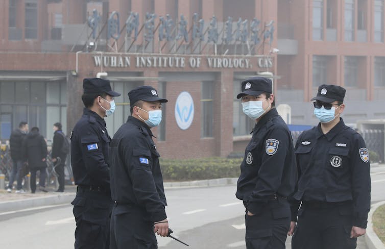 Guardas de segurança mascarados do lado de fora do Instituto de Virologia de Wuhan