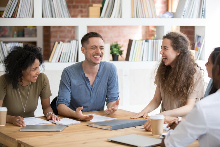 group of young academics laughing and chatting