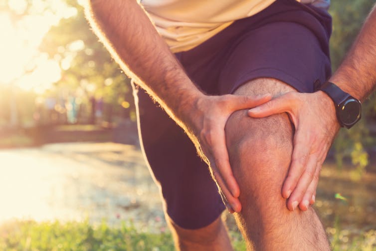 Runner holding a sore knee.