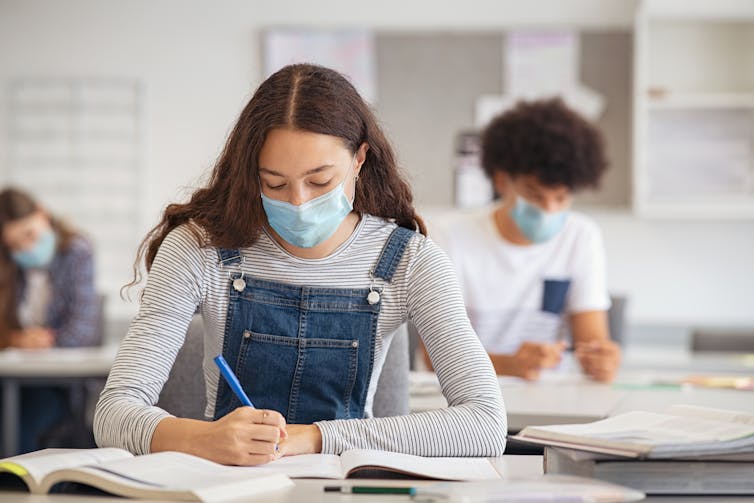 Older students at work in a classroom with masks on.