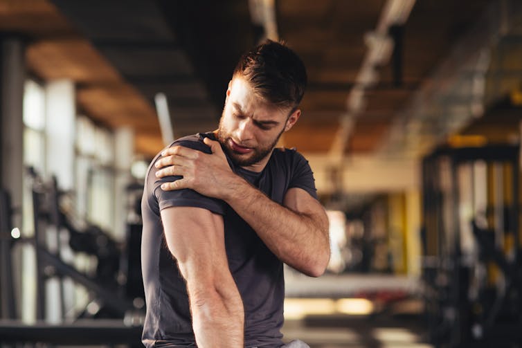 Man holding is shoulder in pain at the gym