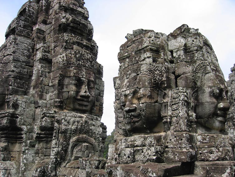 Human faces carved into stone towers of an Angkor temple