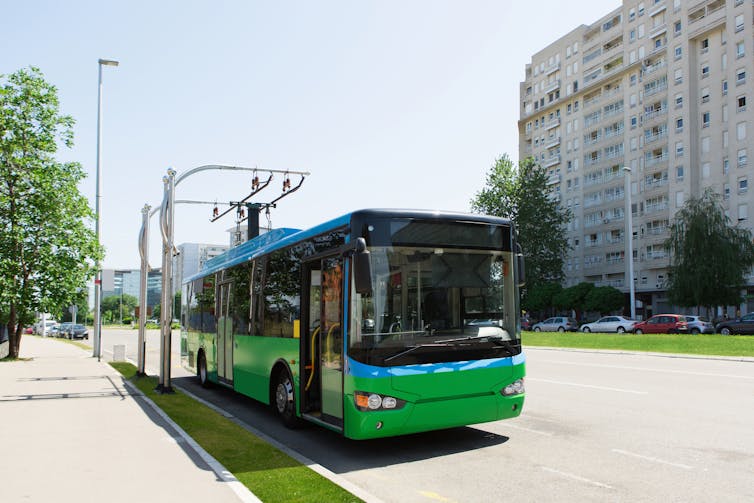 Electric bus being charged on a road