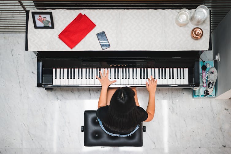 Person playing a piano shot from above