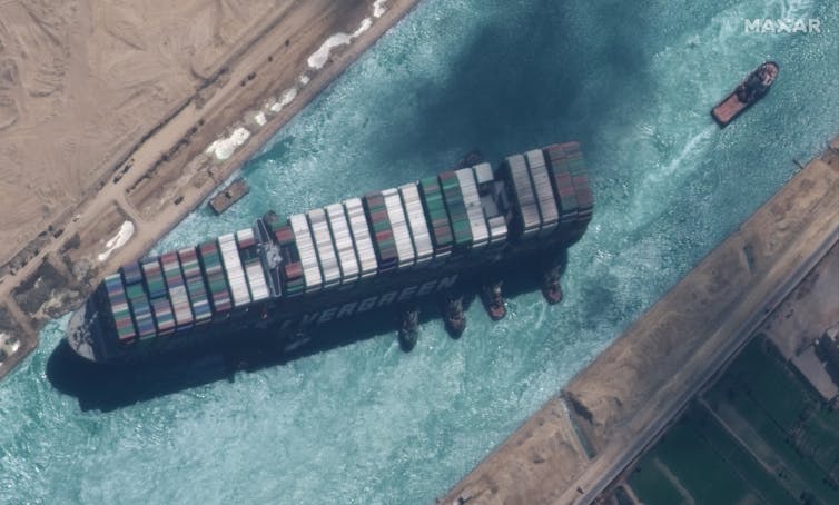 Satellite image showing, the Ever Given container ship after it has been moved away from the eastern bank of the canal with tugs operating on its seaward side.