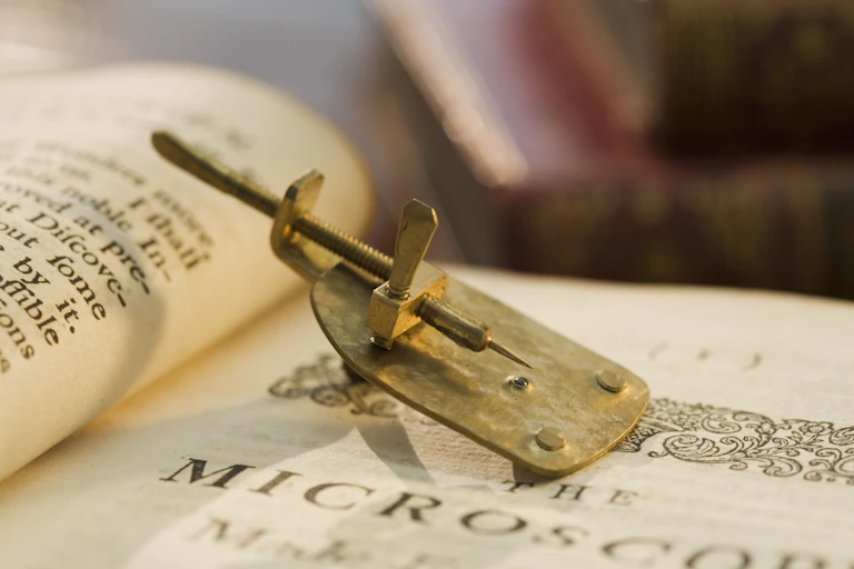 A model of Leeuwenhoek's microscope, which is about the size of a human thumb.