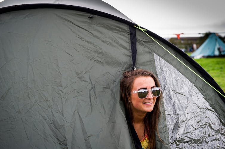 Festival girl poking her head out of a tent