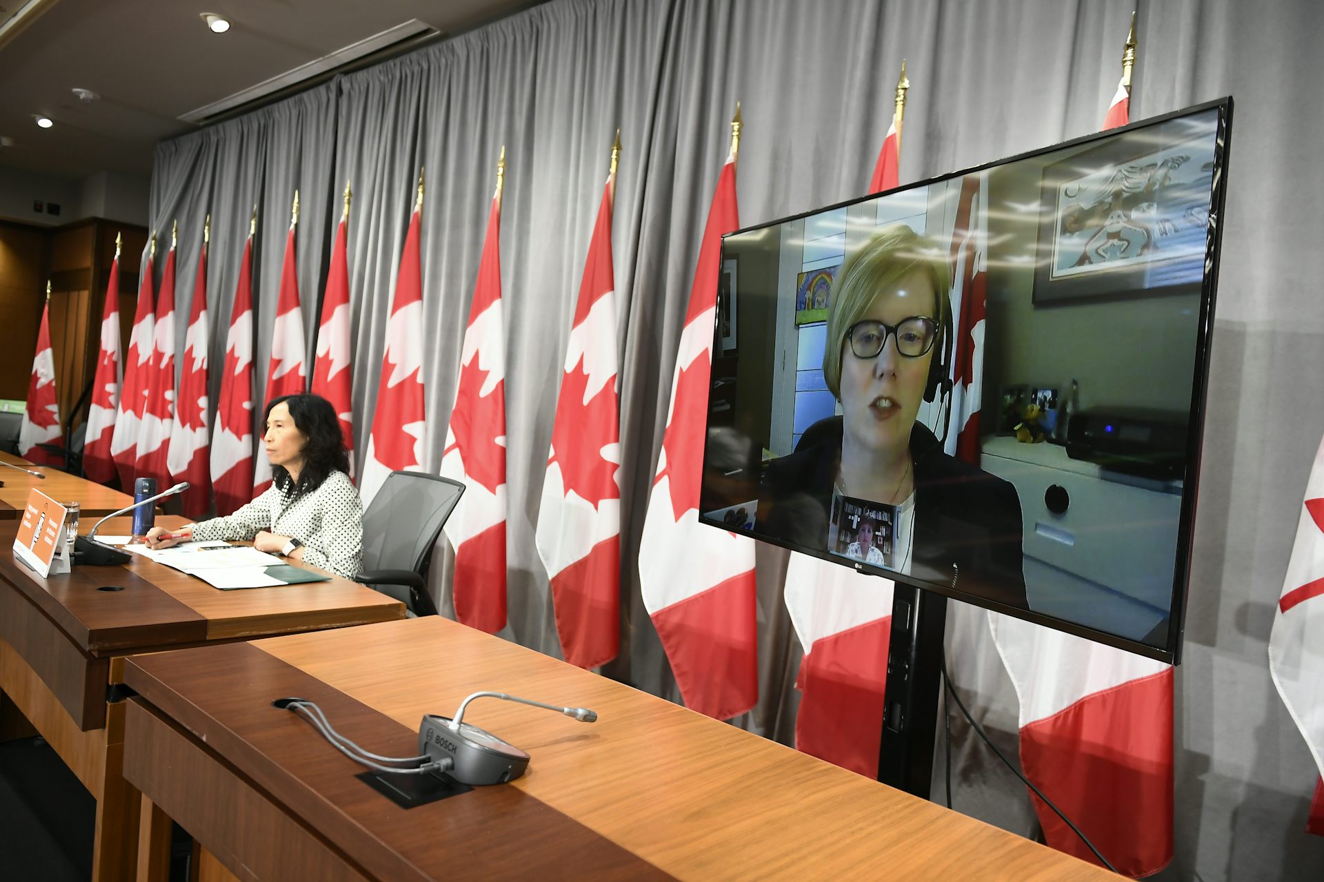 Woman seen on video display at press conference