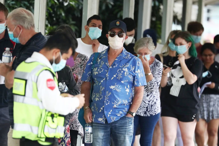 People wearing masks queuing for COVID testing