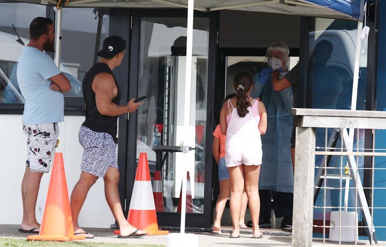 A group of people lining up for COVID testing in Byron Bay.